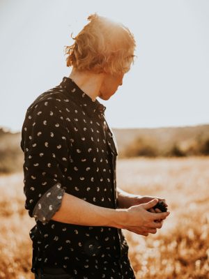 woman in black and white polka dot shirt holding black smartphone